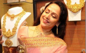 Indian Bollywood actress Hema Malini admires gold necklace