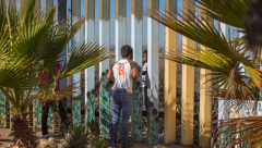 Through the Wall Winner single image in Border category A young man speaks to a family member through the border fence at Friendship Park a meeting place on the border between Tijuana, Mexico and San Diego, California. For many families separated by immigration status, it is the only way that they can see their loved ones in person pic Griselda San Martin