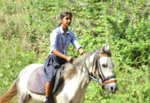 Miss Krishna riding a horse on route to school for SSLC exam