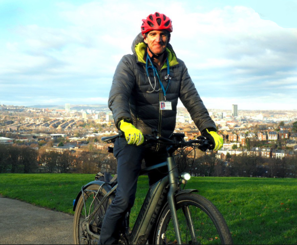 Dr. Oillie Hart on his bike delivering Astrazenecovid vaccine