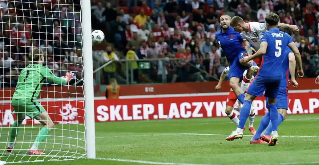 Poland's  substitute  Damian Szymanski who rises high above Luke Shaw to power home his first goal for his country and equalises.